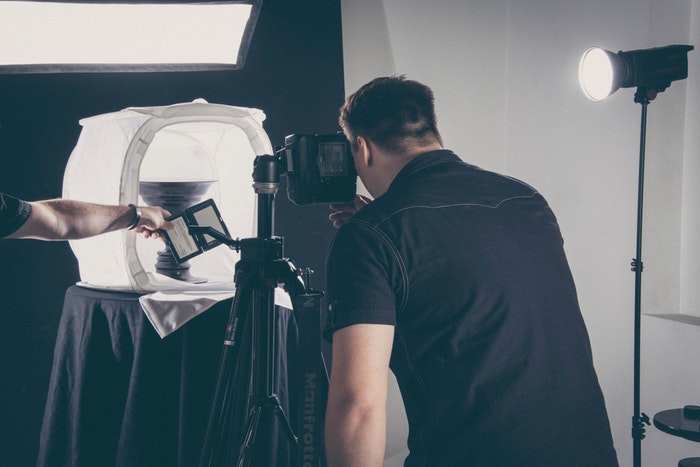 A professional photographer taking a product picture in a studio 