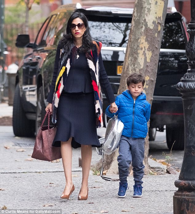 Not a hand to spare: Abedin held a large leather carryall in one hand and her son in the other