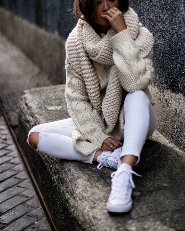 Девушка в свитере крупной вязки и широким воротом