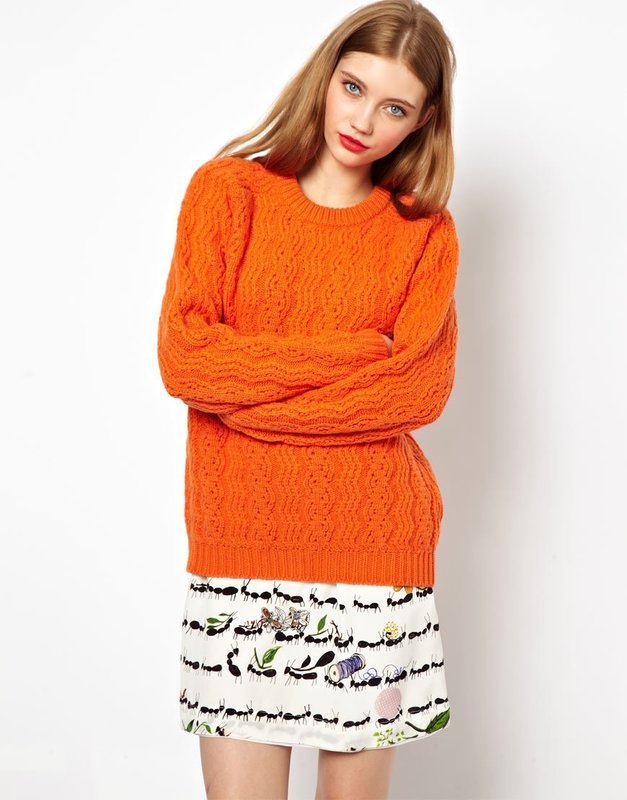 Девушка в оранжевом свитере и юбке