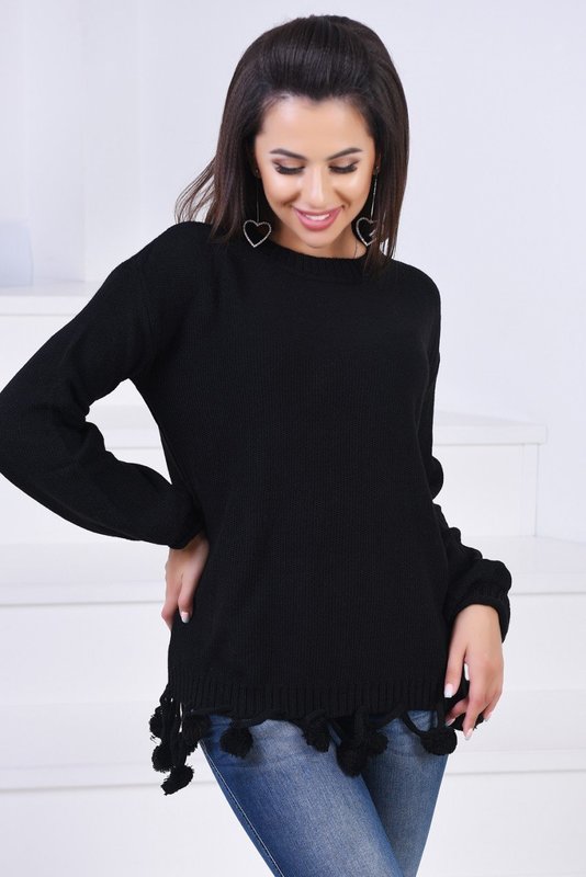 Девушка в черном свитере с помпонами на подоле
