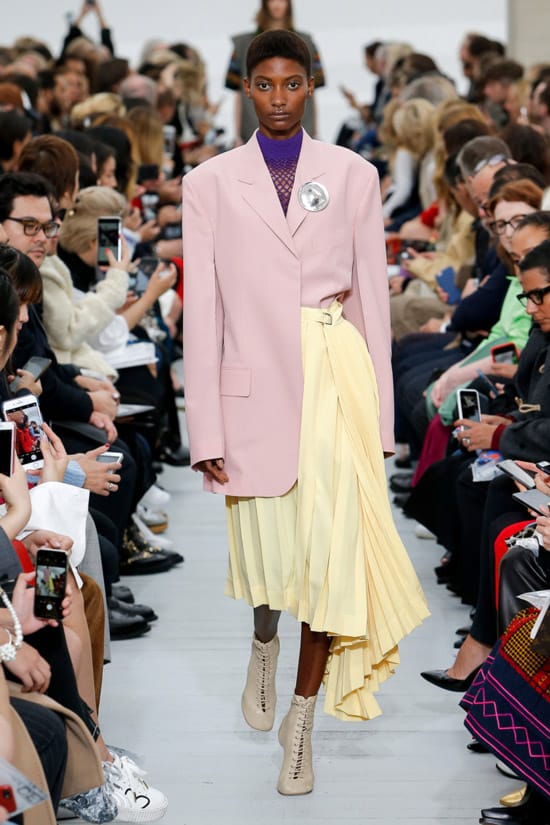 Модель в желтой юбке миди и розовое пальто от Céline